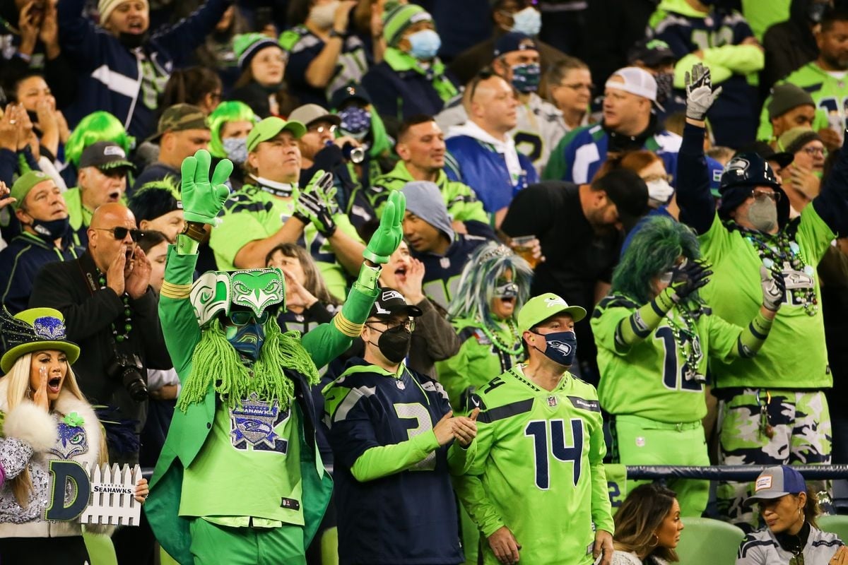Torcedores dos Seahawks uniformizados e fantasiados na arquibancada