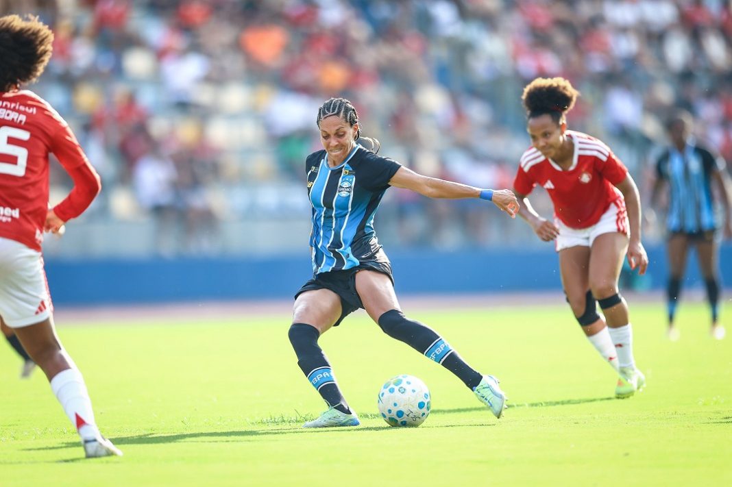 Jogadora do Grêmio Feminino cercada por atletas do Inter Feminino