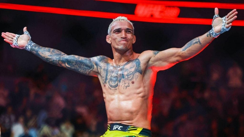 Charles Oliveira comemora vitória nas grades do octógono do UFC