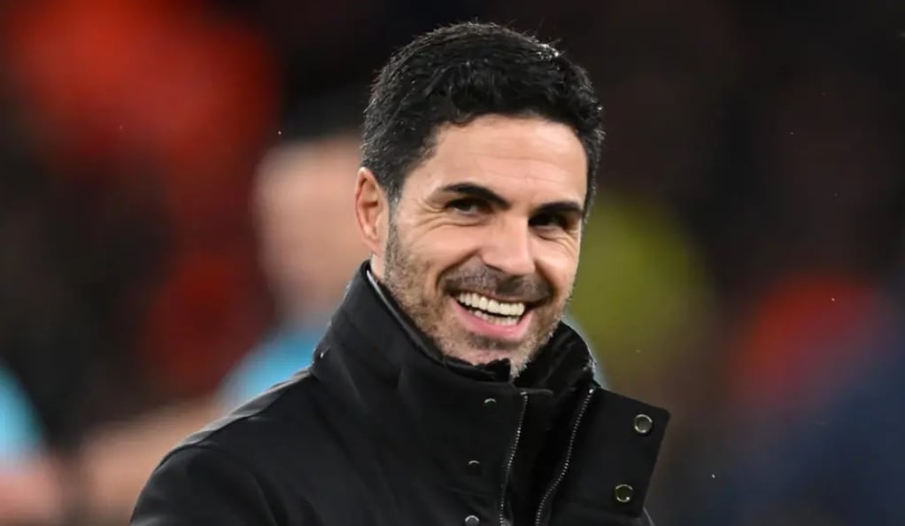 Mikel Arteta sorri ao lado do campo