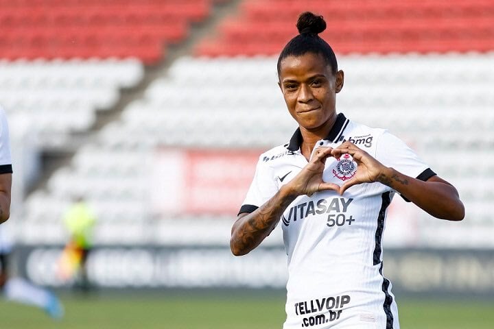 Grazi faz coração com as mãos em volta de escudo do Corinthians Feminino
