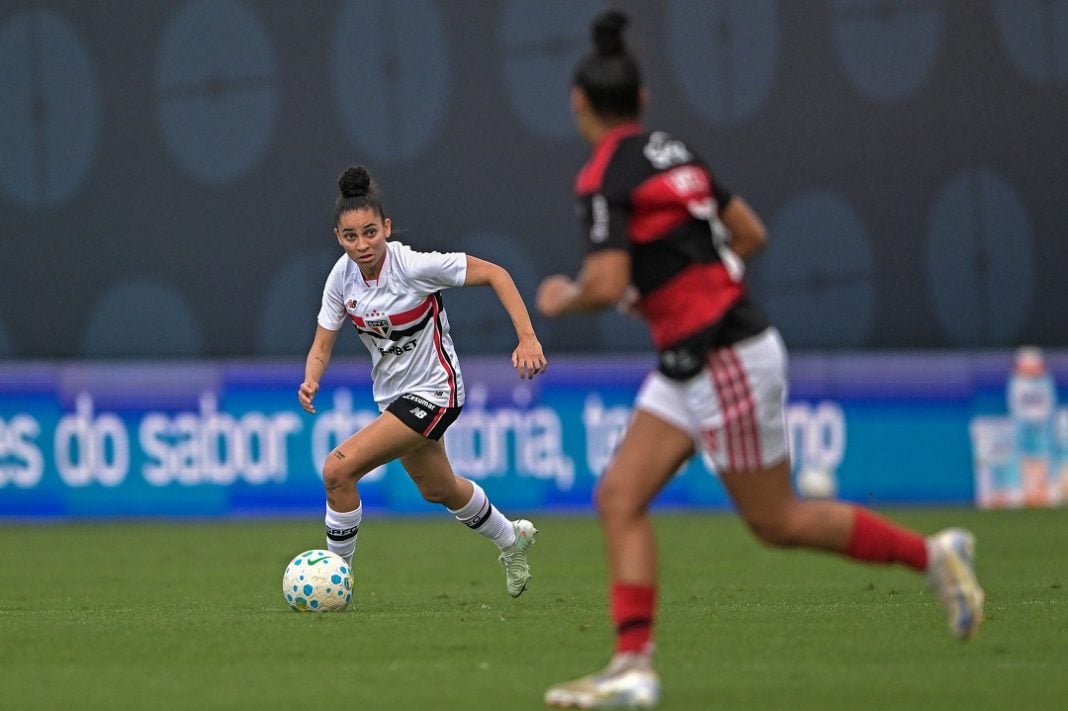 Jogadora do São Paulo Feminino conduz a bola observada por marcadora do Flamengo Feminino